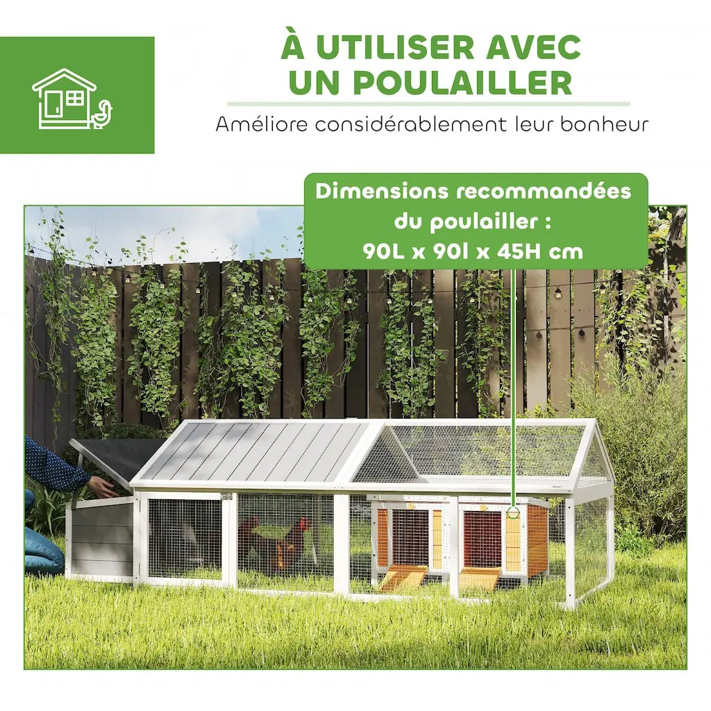 Le parc couvert raccordé à un abri de nuit, posé sur l'herbe le long d'une clôture