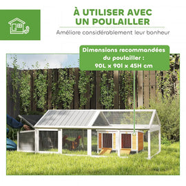 Le parc couvert raccordé à un abri de nuit, posé sur l'herbe le long d'une clôture