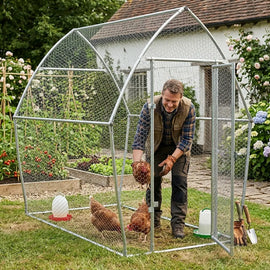 Éleveur debout à l'intérieur du poulailler de 2 m, occupé auprès de trois poules