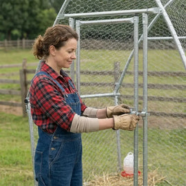Gros plan sur le loquet de la porte du poulailler, manipulé avec des gants de jardin