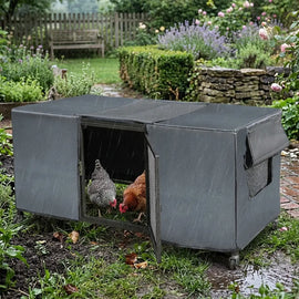 Poulailler mobile couvert de sa bâche imperméable sous la pluie, deux poules à l'abri